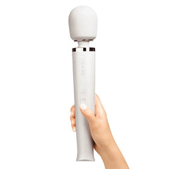 Hand holding upright white Le Wand Rechargeable Massager showing three-button control panel