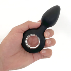 Hand holding the VERS silicone anal plug to show compact, palm-sized scale