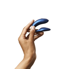 Hand holding We-Vibe Chorus Cosmic Blue to show compact, ergonomic dual-arm size and fit