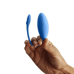 Hand holding We-Vibe Jive open to show flexible silicone loop and smooth egg body in blue