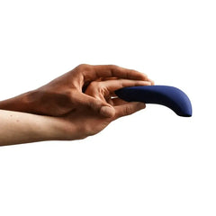 Hand holding We-Vibe Melt clitoral stimulator to demonstrate its compact palm-fit size