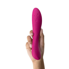 Hand holding the We-Vibe Rave 2 in fuchsia, showing its smooth silicone texture and size