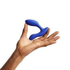 Hand holding We-Vibe Vector+ blue prostate massager to show compact palm-fitting size