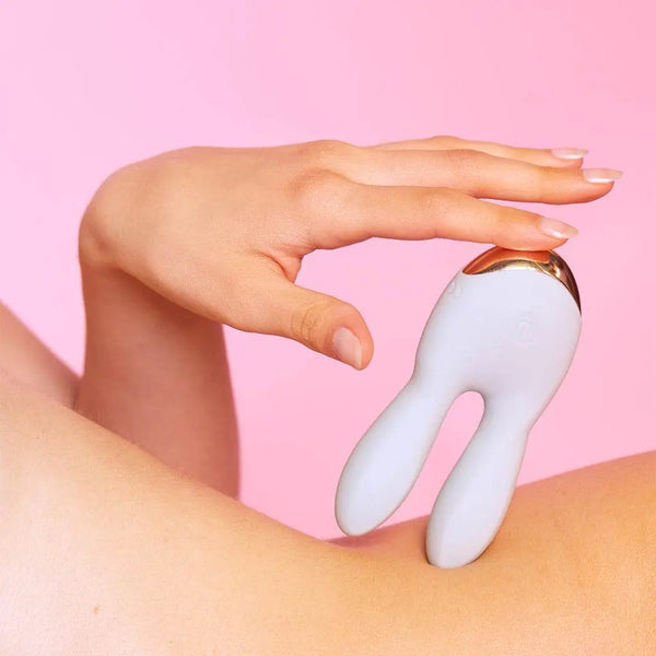 Hand holding white Love to Love rabbit vibrator against skin, demonstrating compact ergonomic size and grip