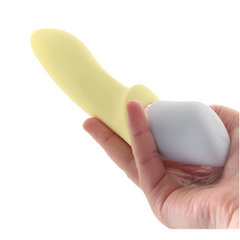 Hand holding yellow Marvelous Four G-spot attachment on grey base showing compact size
