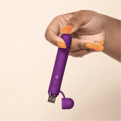 Hand with orange nails holding Le Wand Baton with USB port open, scale context