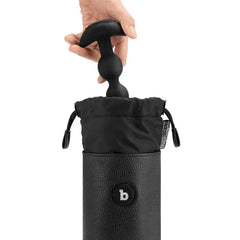 Hand placing a silicone anal toy into the open drawstring top of the b-Vibe UV Sterilizer Pouch
