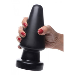 Hand with red nails gripping black Ass Max Large Anal Plug, demonstrating overall product size