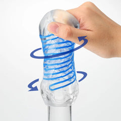 Hand twisting clear Tenga Spinner DX sleeve showing blue spiral rotation motion arrows