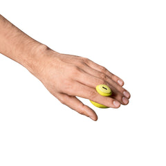 Hand wearing Dame Fin tether on middle finger, vibrator resting on back of hand, top-down view