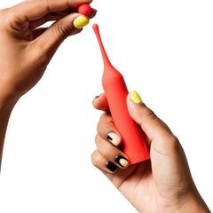 Hands demonstrating removable ball tip on the red ROMP Pop slim-handled vibrator