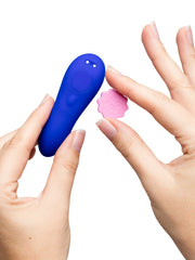 Hands detaching pink scalloped button cap from blue ROMP Party vibrator body