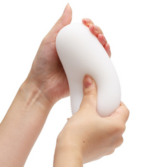 Hands gently squeezing Tenga 3DX ZEN showing flexible, stretchable soft gel material