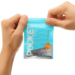 Hands pulling open the resealable top of a Pocket Tenga Wave Line pouch, revealing easy-tear seal