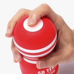 Close-up of hands squeezing the top dome of the red SD Tenga cup to adjust suction