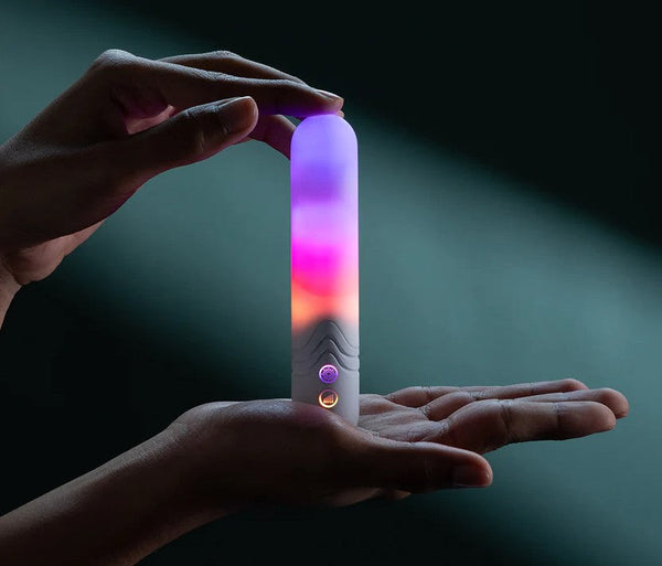 Illumination The Bullet Vibrator by Paradise glowing with multicolour RGB light, held between two hands