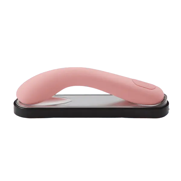 Iroha Mai Toki pink silicone vibrator resting curved-side-up on its sleek black charging tray