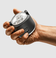 Kiiroo PowerShot interactive male vibrator held in one hand, compact black cylindrical body