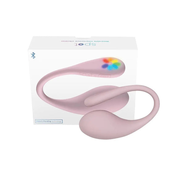 Kiiroo Spot wearable vibrator in pink beside its white retail box with rainbow logo