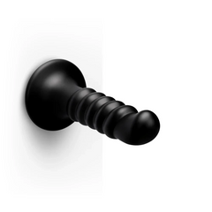 Krush black ribbed dildo mounted horizontally via suction cup on flat surface