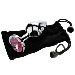Large pink gem anal plug beside its black velvet drawstring storage pouch