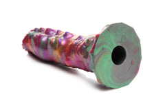 Larva Silicone Dildo lying on its side revealing textured base with center tunnel hole