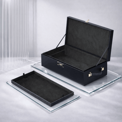 Le Coffret navy case open beside removable black suede inner tray on glass surface