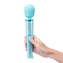 Le Wand All That Glimmers blue glitter wand massager held in hand, power button visible