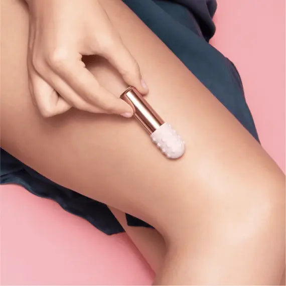 Le Wand Bullet with textured sleeve applied gently to outer thigh for massage