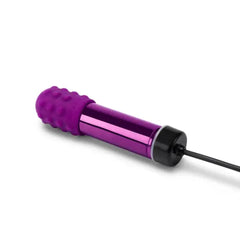 Le Wand Bullet vibrator connected to magnetic USB charging cable at the base