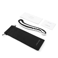 Le Wand Contour wand laid beside black storage bag, warranty card, and care guide