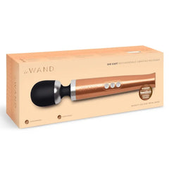 Le Wand Die Cast Rechargeable Massager in rose gold shown inside its peach retail packaging box