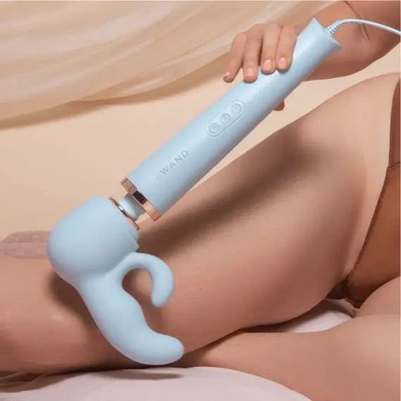 Le Wand Dual attachment on wand massager held against upper thigh, lifestyle view