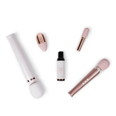 Le Wand lubricant bottle displayed alongside a collection of rose gold personal massager accessories
