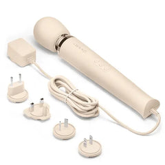 Le Wand massager beside four interchangeable international plug adapters for global use