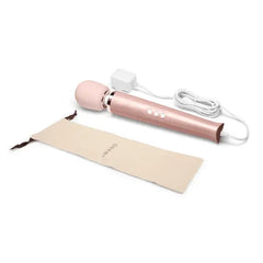 Le Wand massager beside its included cream cotton storage pouch and white charging adapter