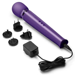 Le Wand wand massager with included charger and four international plug adapters on white background