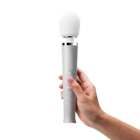 Le Wand Petite All That Glimmers wand massager held in hand, silver glitter handle