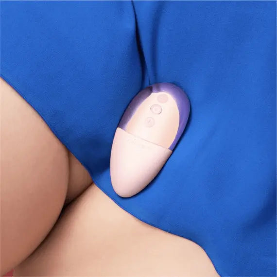 Le Wand Point lay-on vibrator resting against a person's thigh draped in blue fabric