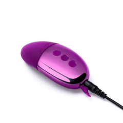 Le Wand Point vibrator connected to USB charging cable via magnetic port on chrome base