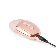 Le Wand Point vibrator connected to USB charging cable via port on rose gold base