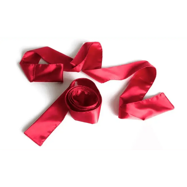 Liberator Silky Tie Ups in red satin, loosely coiled with flowing ends on white background