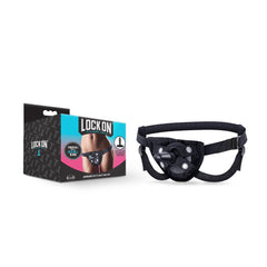 Lock On strap-on harness in black with suction-cup base plate, shown beside product box
