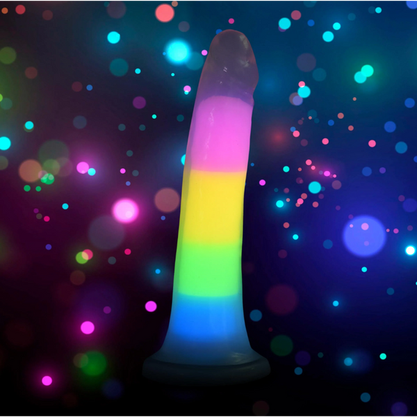 Lollicock Glow rainbow dildo standing upright against colourful bokeh light background