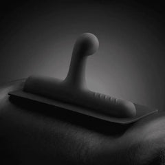Close-up of Lone Ranger matte black silicone attachment resting on a dark leather surface