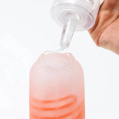 Lotion being applied from nozzle into a pink textured sleeve, demonstrating precise dispensing control