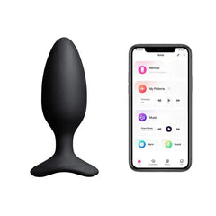 Lovense Hush 2 butt plug beside smartphone showing Lovense app control interface