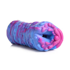 Low-angle view of Cyclone alien stroker resting horizontally, textured opening facing viewer
