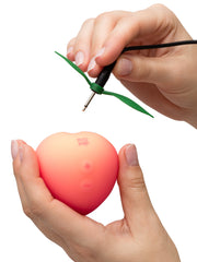 Magnetic charging cable connecting to the stem of the ROMP Pink Peach stimulator