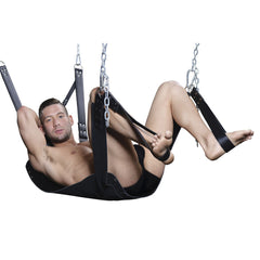 Male model reclined in suspended black leather sling with ankle stirrups and chain rigging